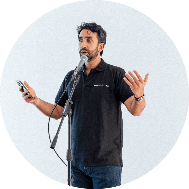 Man speaking at a brand presentation event with microphone and phone.